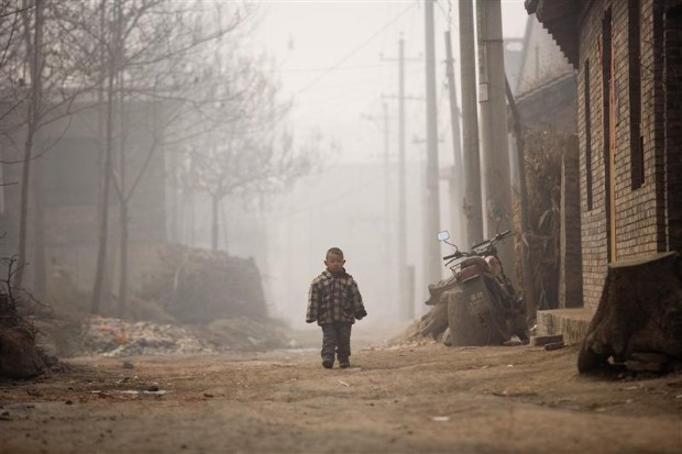 A small boy walks through the smog of Donglu, on the outskirts of Linfen, where villagers have difficulty in selling their crops because of the severe pollution. Linfen, a city of about 4.3 million, is one of the most polluted cities in the world. China's increasingly polluted environment is largely a result of the country's rapid development and consequently a large increase in primary energy consumption, which is almost entirely produced by burning coal.